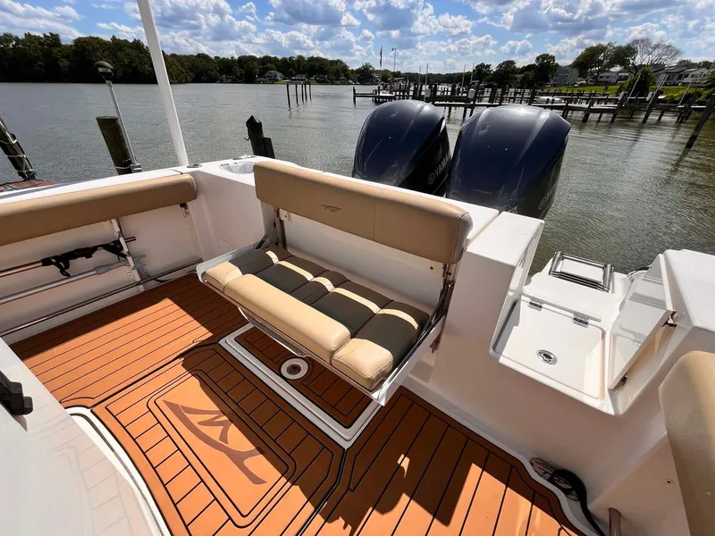 Slide: The Image of 2015 Tidewater 280 CC Adventure boat with tan seating and dual engines on a sunny day. - 21