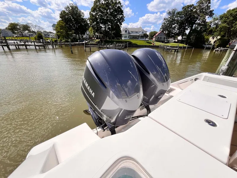 Slide: The Image of 2015 Tidewater 280 CC Adventure with twin Yamaha outboard motors docked by a scenic waterfront. - 22
