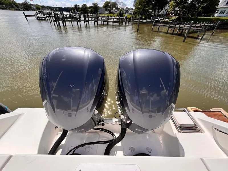 Slide: The Image of Twin outboard motors on a 2015 Tidewater 280 CC Adventure boat by a dock. - 23