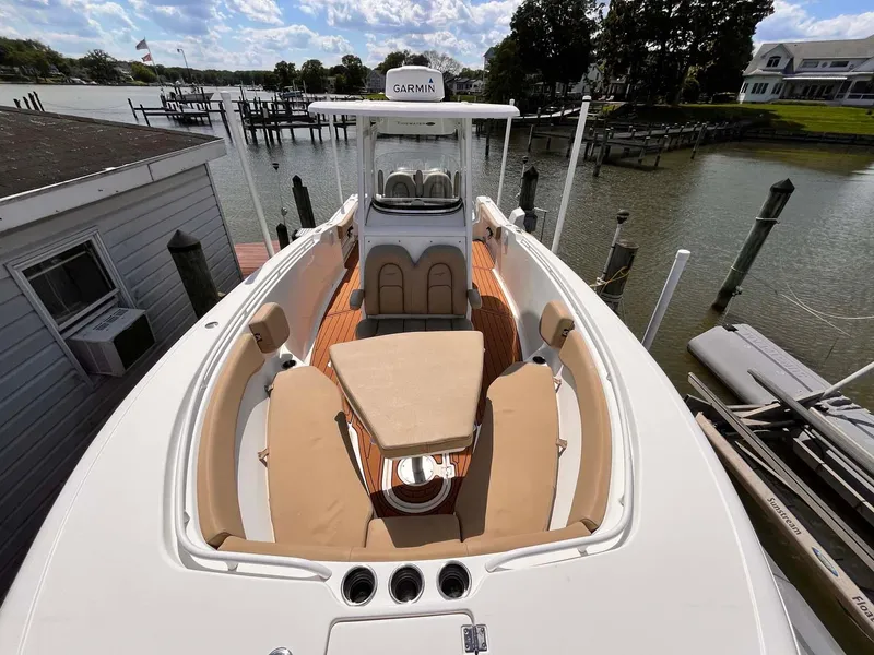 Slide: The Image of 2015 Tidewater 280 CC Adventure boat docked by a serene waterfront. - 5