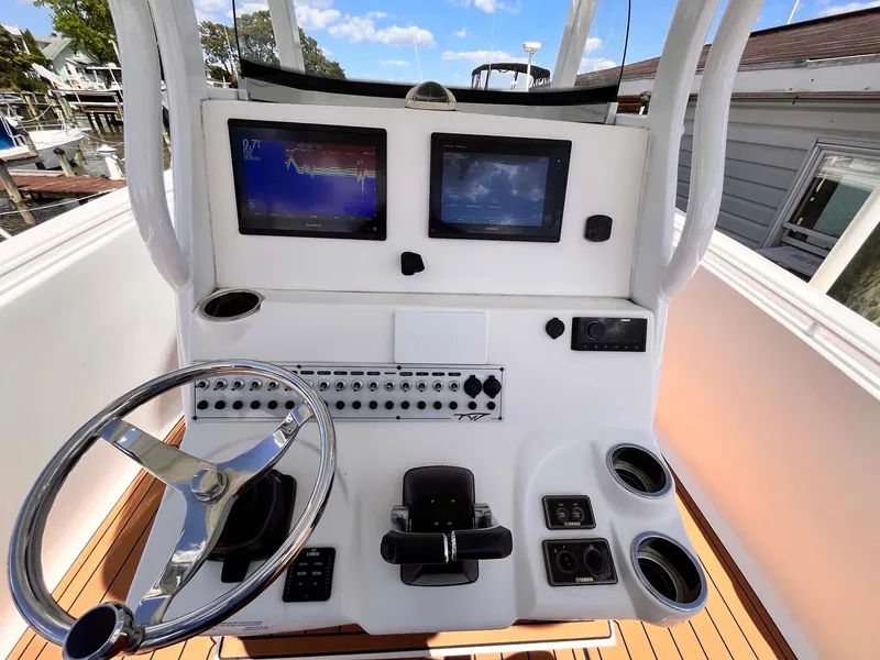 Slide: The Image of 2015 Tidewater 280 CC Adventure boat helm with dual screens and controls. - 7
