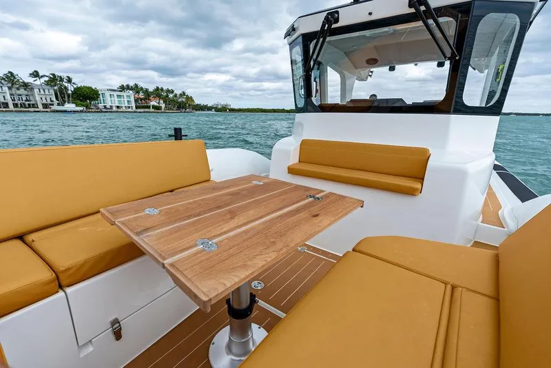 Slide: The Image of Rafnar Targa 40 boat interior with wooden table and tan seating, 2022 model. - 25