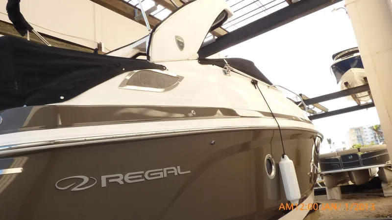 Slide: The Image of 2018 Regal 28 Express boat in storage, side view with logo visible. - 20