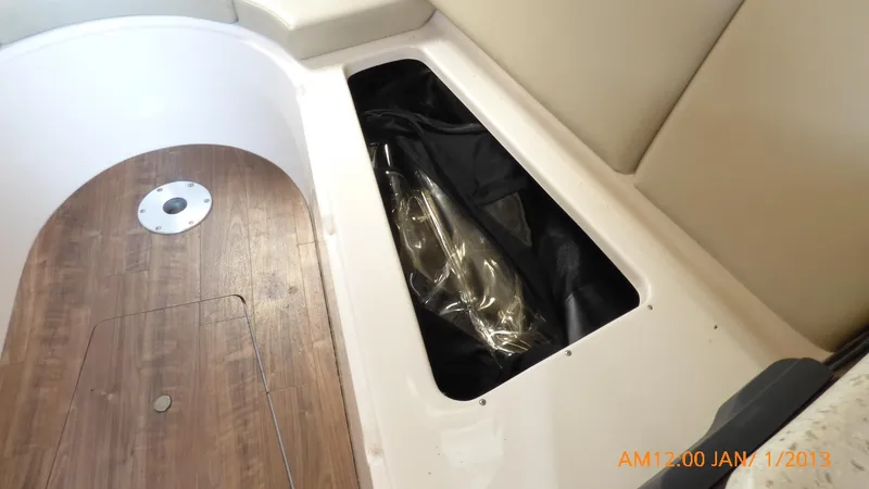 Slide: The Image of 2018 Regal 28 Express boat interior storage compartment with wood flooring. - 35
