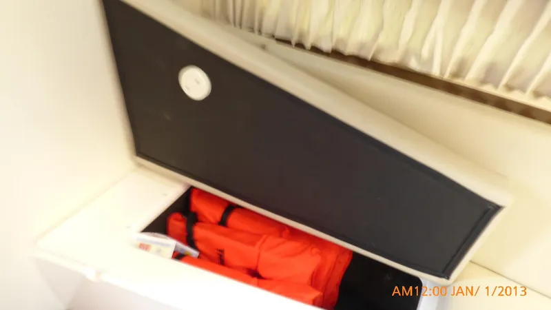 Slide: The Image of Storage compartment with life jackets on a 2018 Regal 28 Express boat. - 37