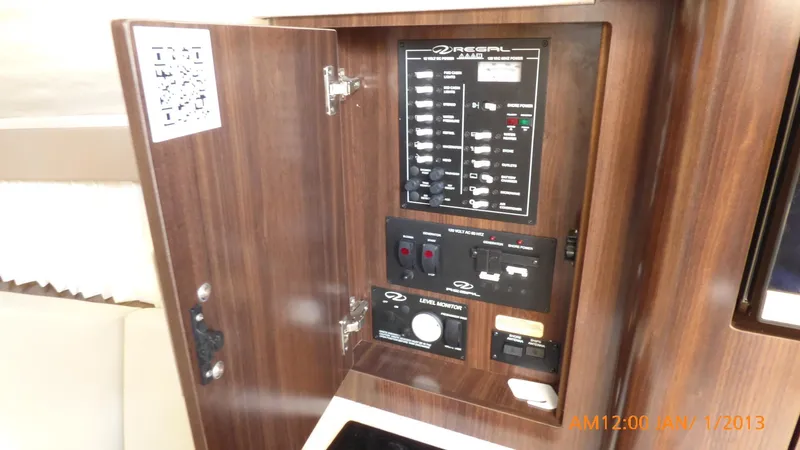 Slide: The Image of Electrical panel inside 2018 Regal 28 Express boat, featuring control switches and circuit breakers. - 41