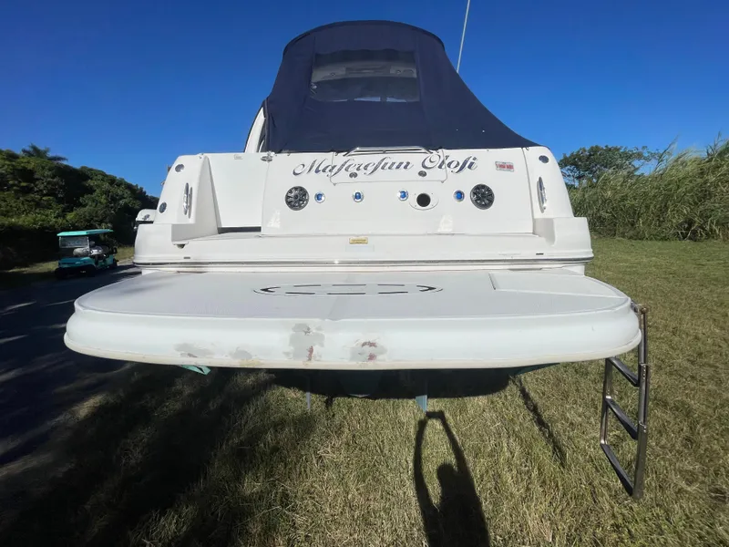 Slide: The Image of 2006 Sea Ray 320 Sundancer boat with swim platform and ladder, parked on grass. - 21