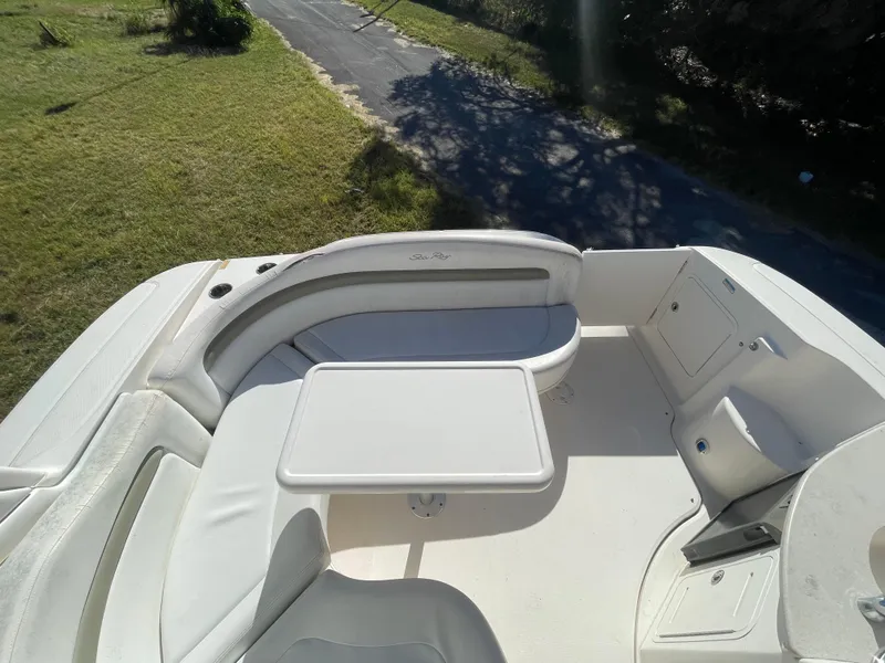Slide: The Image of 2006 Sea Ray 320 Sundancer boat deck with seating and table, sunny outdoor setting. - 33