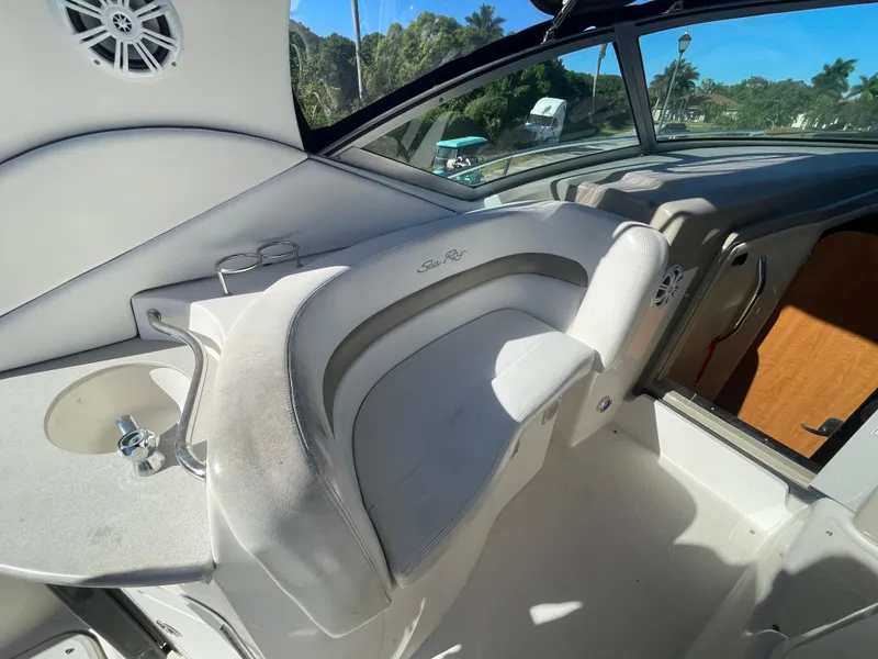 Slide: The Image of 2006 Sea Ray 320 Sundancer cockpit with seating and speaker, sunny day view. - 51