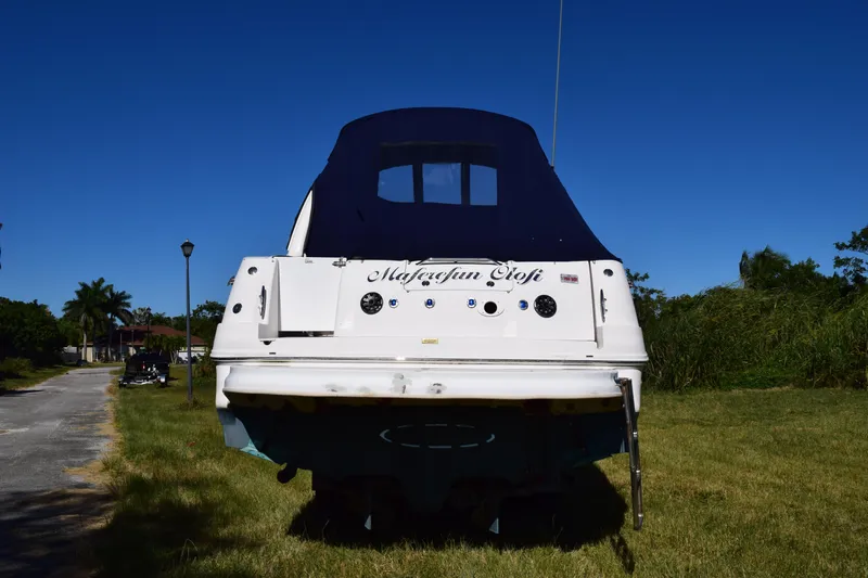 Slide: The Image of 2006 Sea Ray 320 Sundancer boat on grass, rear view, blue canopy. - 6