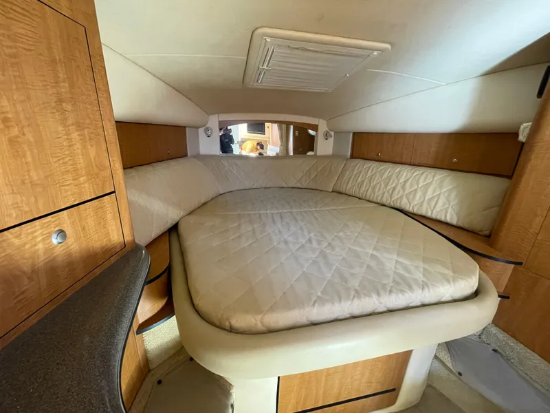 Slide: The Image of Interior cabin of 2006 Sea Ray 320 Sundancer with cozy bed and wood accents. - 66