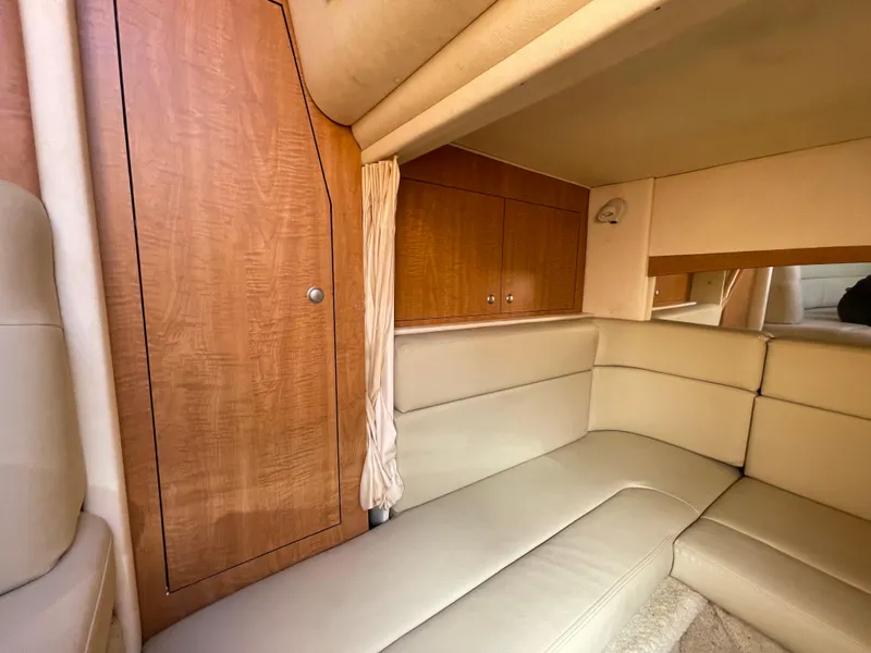 Slide: The Image of Interior of 2006 Sea Ray 320 Sundancer with beige seating and wooden cabinetry. - 80