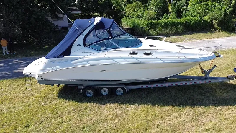 Slide: The Image of 2006 Sea Ray 320 Sundancer boat on trailer, parked on grass. - 9