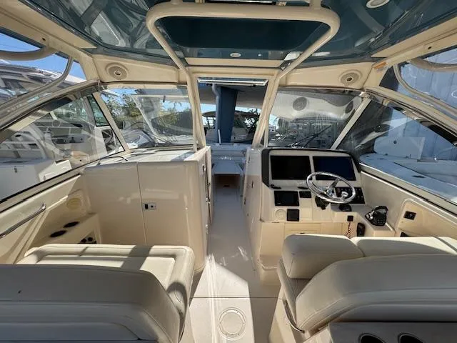 Slide: The Image of 2018 Grady-White Freedom 325 boat interior with helm, seating, and panoramic windows. - 15