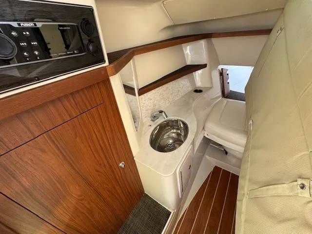 Slide: The Image of 2018 Grady-White Freedom 325 cabin interior with wood accents and compact sink area. - 21