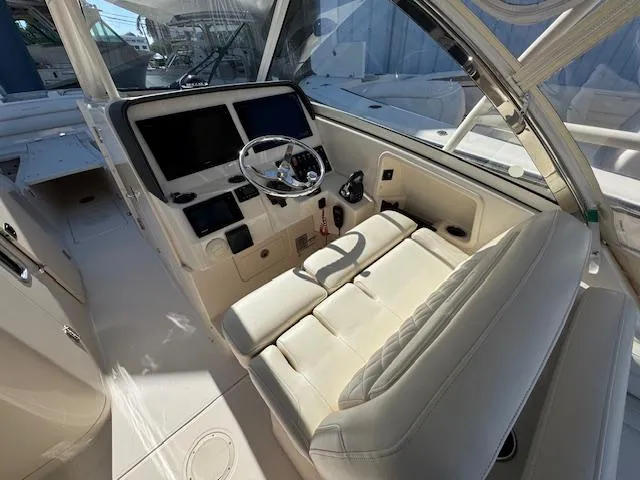 Slide: The Image of 2018 Grady-White Freedom 325 boat cockpit with dual screens and plush seating. - 24