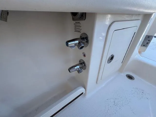 Slide: The Image of 2018 Grady-White Freedom 325 boat interior, featuring control knobs and storage compartment. - 26