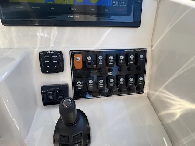 Slide: The Image of Control panel of a 2018 Grady-White Freedom 325 boat with switches and joystick. - 31