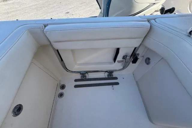 Slide: The Image of 2018 Grady-White Freedom 325 boat interior with white seating and storage compartment. - 36