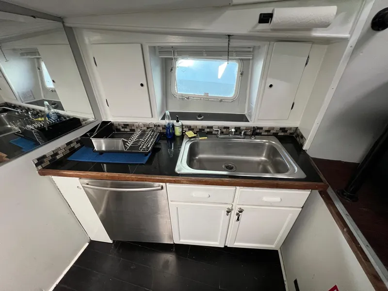 Slide: The Image of 1975 Hatteras 58 Motor Yacht kitchen with sink, dishwasher, and window. - 17