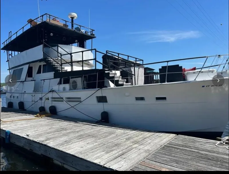 Slide: The Image of 1975 Hatteras 58 Motor Yacht docked under clear blue sky. - 2