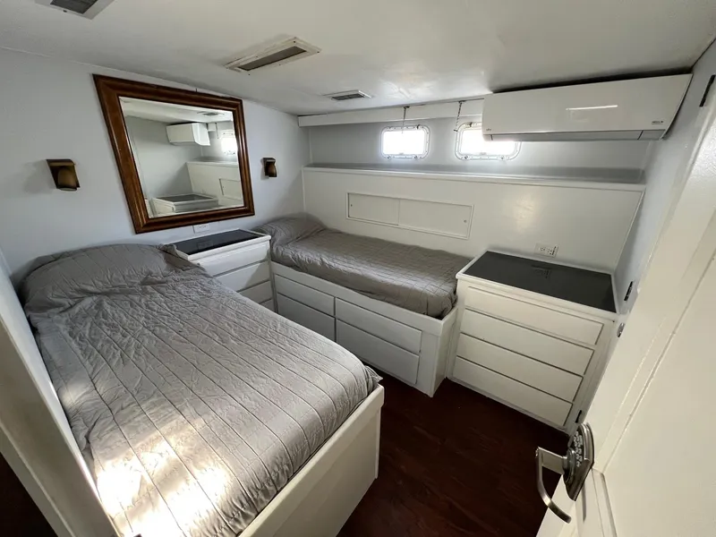 Slide: The Image of 1975 Hatteras 58 Motor Yacht cabin with twin beds and modern decor. - 23