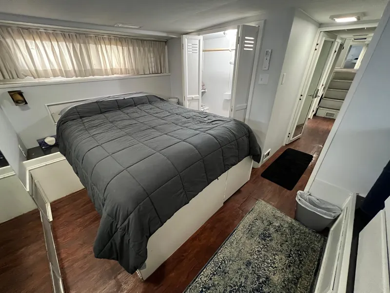 Slide: The Image of 1975 Hatteras 58 Motor Yacht bedroom with gray bedding and wood flooring. - 32