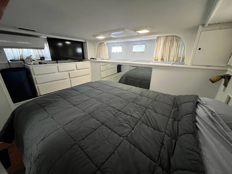Slide: The Image of Interior of 1975 Hatteras 58 Motor Yacht bedroom with bed, TV, and storage. - 33