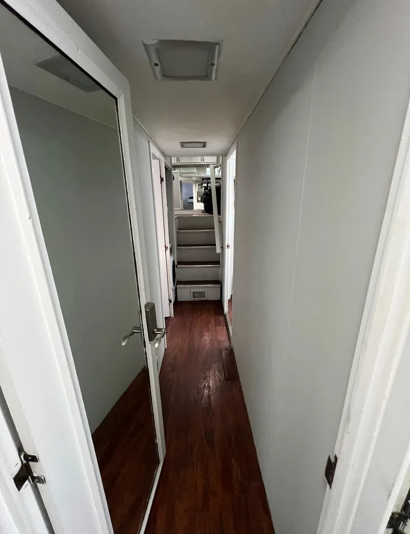 Slide: The Image of Interior hallway of 1975 Hatteras 58 Motor Yacht with wooden flooring and white walls. - 35