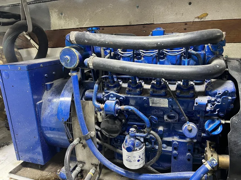 Slide: The Image of Engine of a 1975 Hatteras 58 Motor Yacht, showcasing blue components and hoses. - 41