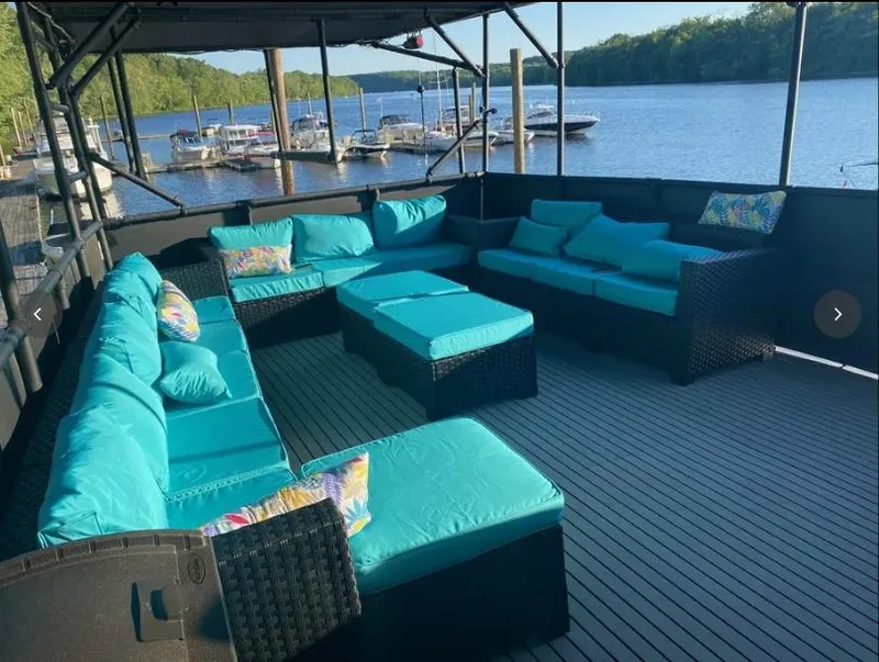 Slide: The Image of Spacious deck of 1975 Hatteras 58 Motor Yacht with turquoise seating, overlooking serene waters. - 5