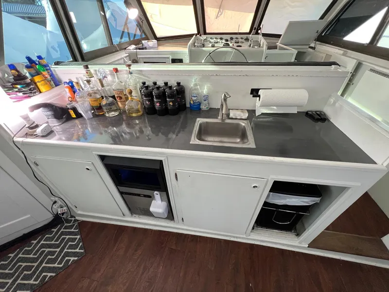 Slide: The Image of 1975 Hatteras 58 Motor Yacht bar area with sink, countertop, and beverage bottles. - 9
