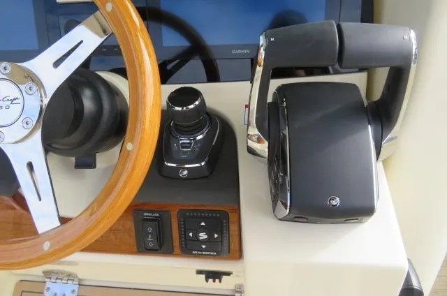 Slide: The Image of 2025 Chris-Craft Catalina 28 helm with steering wheel and throttle controls. - 27