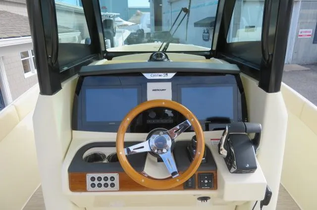 Slide: The Image of 2025 Chris-Craft Catalina 28 helm with modern controls and wooden steering wheel. - 28