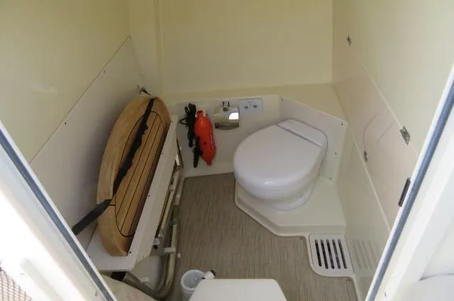 Slide: The Image of 2025 Chris-Craft Catalina 28 boat interior bathroom with toilet and storage space. - 30