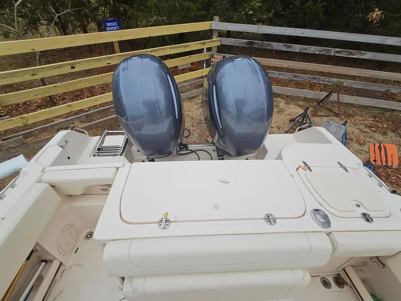 Slide: The Image of 2022 Grady-White Fisherman 257 boat with dual outboard motors, docked near wooden fence. - 2