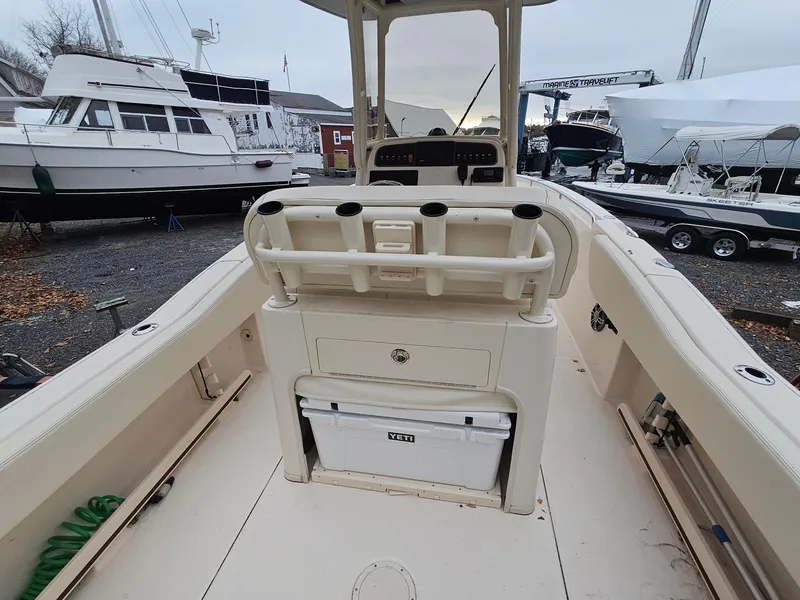 Slide: The Image of 2022 Grady-White Fisherman 257 boat interior with storage and seating, docked near other boats. - 3