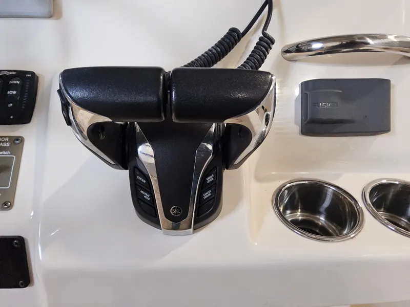 Slide: The Image of Control panel of 2022 Grady-White Fisherman 257 boat with throttle and cup holders. - 7