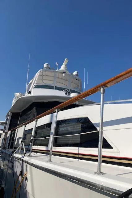 Slide: The Image of 1977 Bertram 58 Motor Yacht with sleek design against clear blue sky. - 1