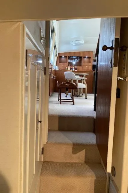 Slide: The Image of Interior view of a 1977 Bertram 58 Motor Yacht, featuring a cozy dining area. - 11