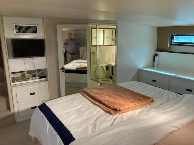 Slide: The Image of 1977 Bertram 58 Motor Yacht bedroom with TV, mirror, and ensuite bathroom. - 13