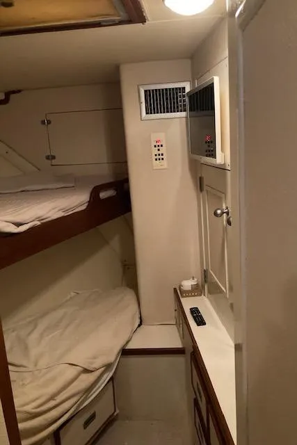 Slide: The Image of 1977 Bertram 58 Motor Yacht cabin with bunk beds and storage. - 16