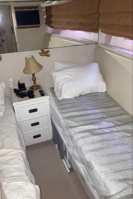 Slide: The Image of Interior cabin of a 1977 Bertram 58 Motor Yacht with twin beds and a nightstand. - 17