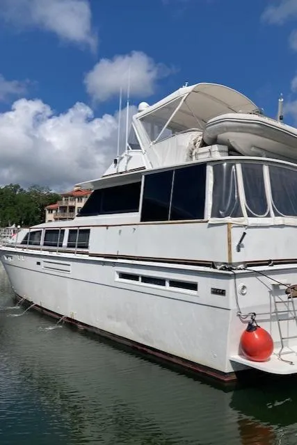 Slide: The Image of 1977 Bertram 58 Motor Yacht docked under a clear blue sky. - 4