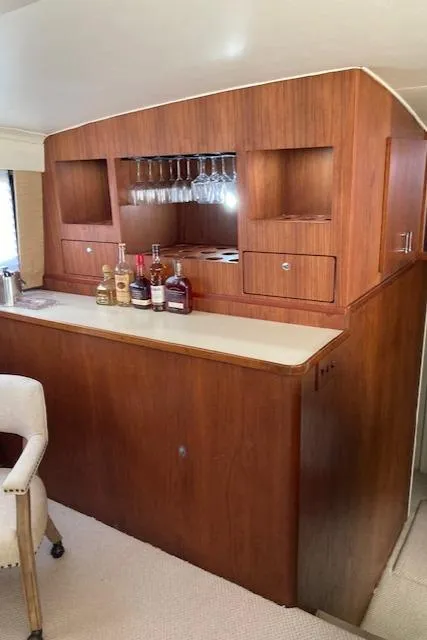 Slide: The Image of 1977 Bertram 58 Motor Yacht interior with wooden bar and glass storage. - 6
