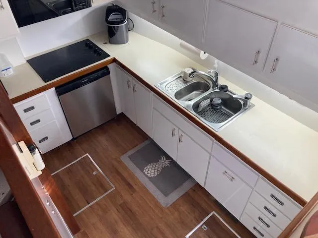 Slide: The Image of 1977 Bertram 58 Motor Yacht kitchen with modern appliances and wooden flooring. - 9