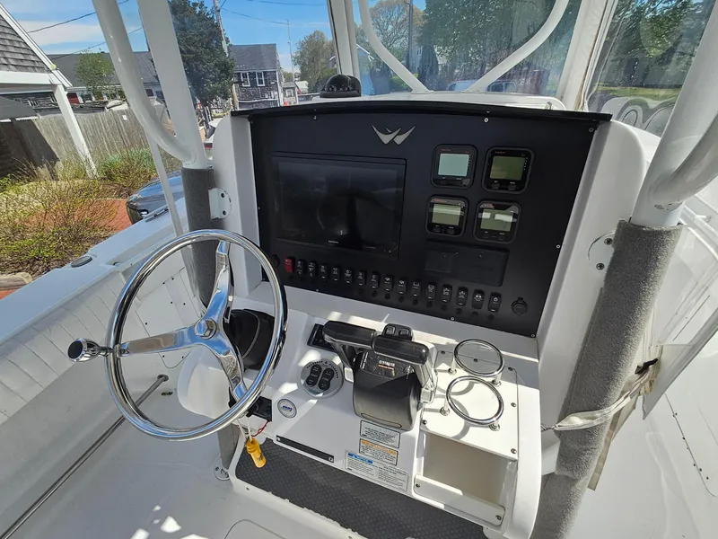 Slide: The Image of 2007 Southport 26 Center Console boat dashboard with steering wheel and control panel. - 19