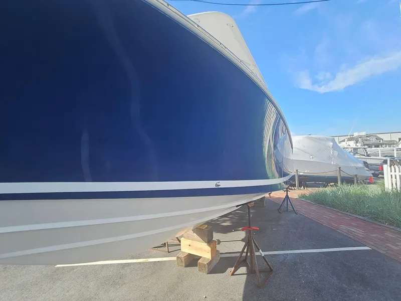 Slide: The Image of 2007 Southport 26 Center Console boat on stands, blue hull, outdoor setting. - 2