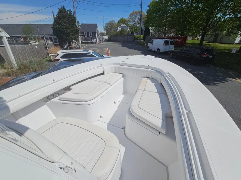 Slide: The Image of 2007 Southport 26 Center Console boat with white seating, parked in a residential area. - 26