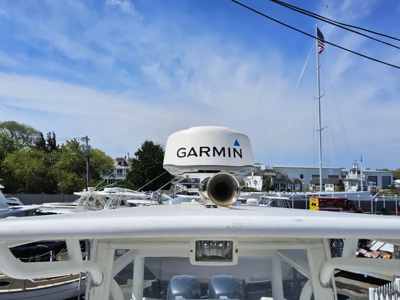 Slide: The Image of 2007 Southport 26 Center Console with Garmin radar, docked under a clear blue sky. - 29